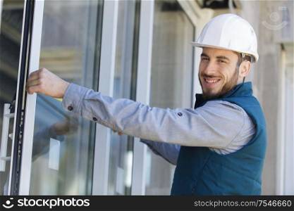 man in hard hat measuring window