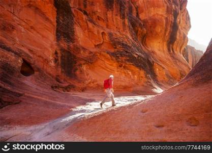Man in hike in the slot canyon in summer mountains. Utah, USA