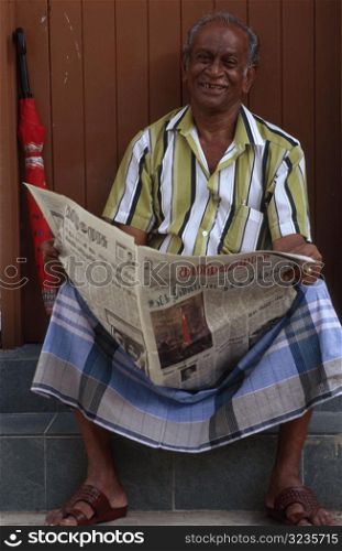 Man in India Reading Paper
