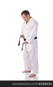 Man in karate-gi fastening his black belt