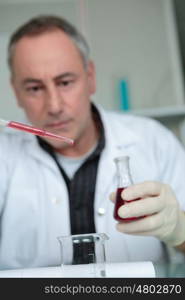 man in laboratory with pipette in the clinic research