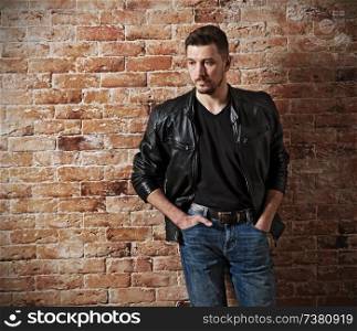 Man in leather clotes on brick background (HDR version)