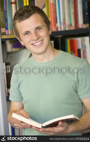 Man in library holding book