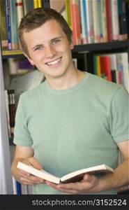 Man in library holding book