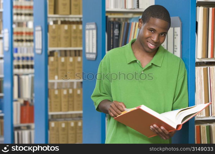 Man in library holding book (depth of field)