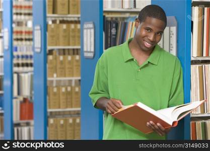 Man in library holding book (depth of field)
