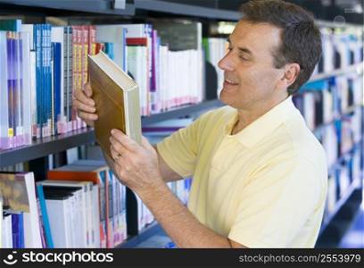 Man in library looking at book (depth of field)