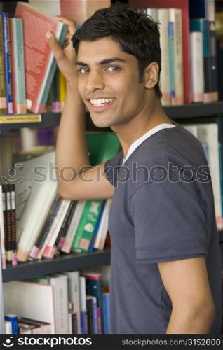 Man in library pulling book off shelf