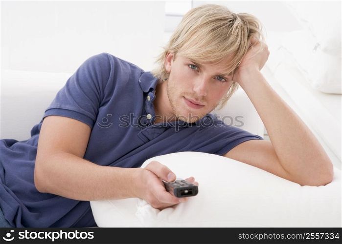 Man in living room holding remote control