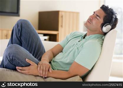 Man in living room listening to headphones sleeping