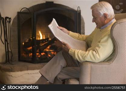 Man in living room reading newspaper