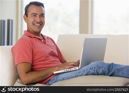 Man in living room using laptop smiling