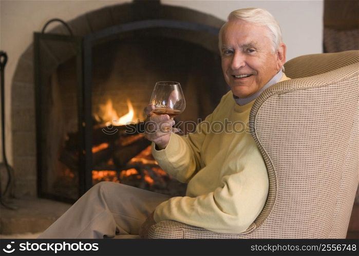 Man in living room with drink smiling