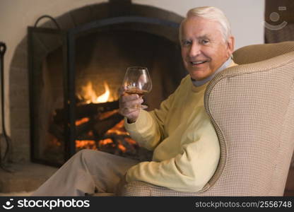 Man in living room with drink smiling