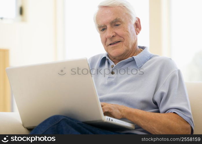 Man in living room with laptop smiling