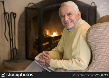 Man in living room with newspaper smiling