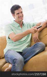 Man in living room with remote control smiling