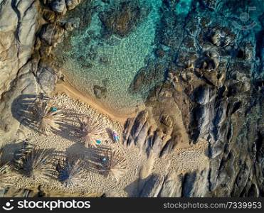 Man in lounger on a beautiful beach aerial view drone shot, Sithonia, Greece