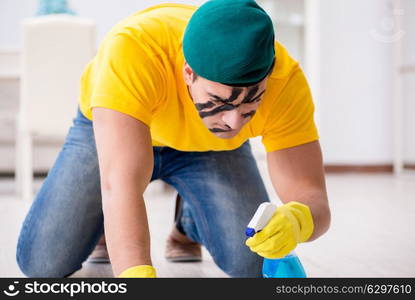 Man in military style cleaning the house