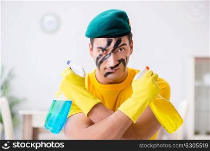 Man in military style cleaning the house