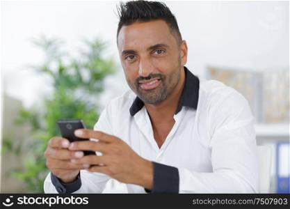 man in office wear using a phone indoors