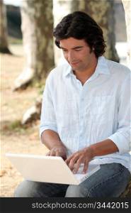 Man in park using laptop