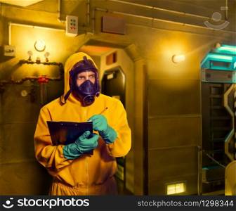 Man in protective suit with respiratory mask making notes. Man in protective suit