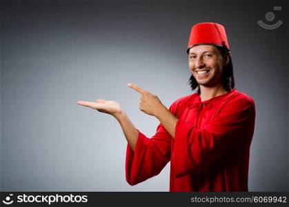 Man in red dress wearing fez hat