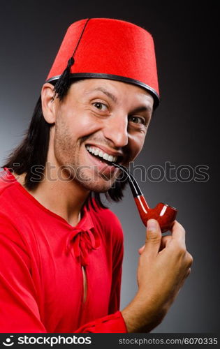 Man in red dress wearing fez hat