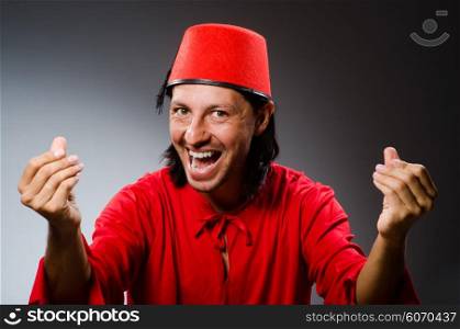 Man in red dress wearing fez hat