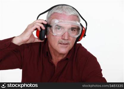 Man in safety goggles and ear defenders