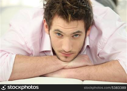 Man in shirt laying on his bed after hard days work