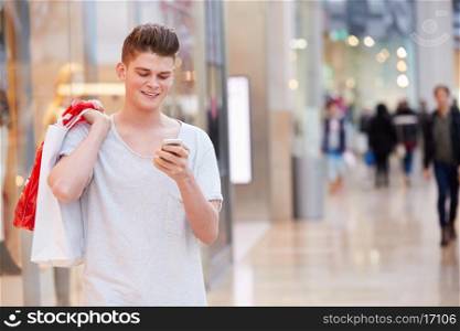 Man In Shopping Mall Using Mobile Phone