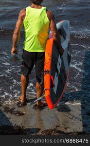 Man in Shoreline with His Board Underarm before Surfing in the Sea