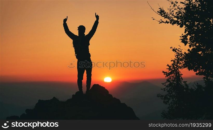 Man in silhouette in front of idyllic sunset in the hills. In autumn