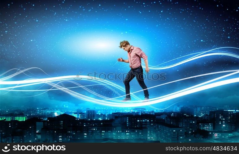 Man in sky. Young man walking on light rays in sky