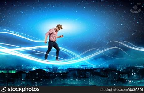 Man in sky. Young man walking on light rays in sky