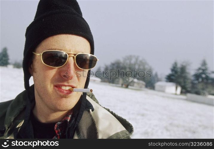 Man in Snowy Field with Cigarette in Mouth