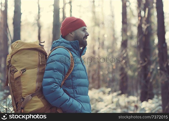 man in sports down jacket landscape winter trekking / down jacket on a tourist, outdoor activities in the north, seasonal landscape