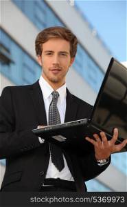 Man in suit carrying a laptop