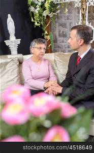 Man in suit comforting elderly lady