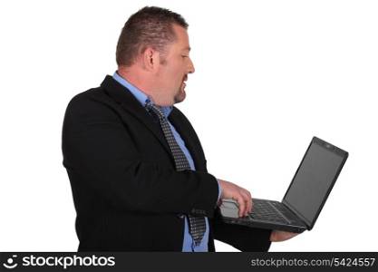 Man in suit holding laptop computer, studio shot