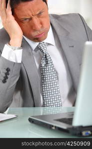 Man in suit staring at laptop