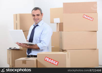 Man in suit surrounded by stacks of boxes