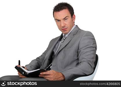 Man in suit writing in diary
