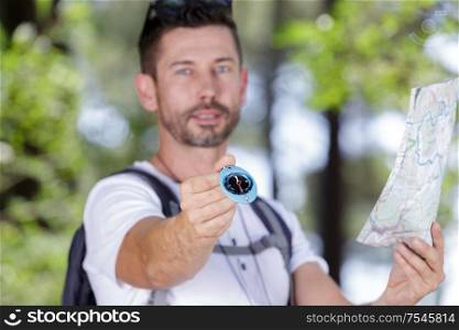 man in the countryside with map showing compass