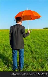 man in the field with orange umbrella