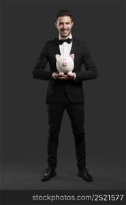Man in tuxedo holding a pig money box