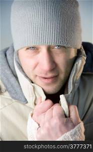 Man in warm gray jacket and hat. Close up.
