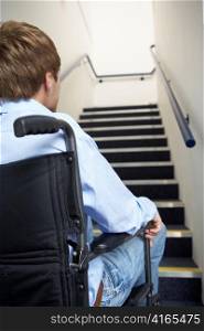 Man in wheelchair at foot of stairs